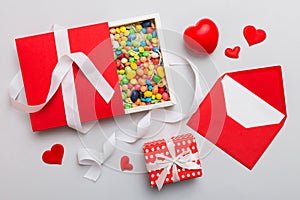 Valentine day composition: sweet candy, with gift boxes with bow and red felt hearts, photo template, background. Top