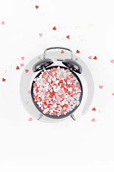 Valentine Day concept with alarm clock and hearts
