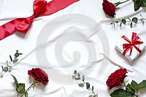 Valentine day concept frame on the white blanket . Holiday top view card with red roses.