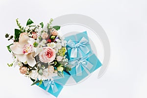 Valentine Day or Mother Day concept. Flower bouquet with gift on white background. Flat lay top view floral composition