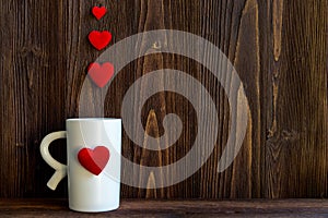 Valentine Day with white cup coffee Sewed pillow hearts row border, old wood background,