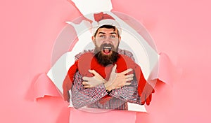 Valentine day. Winter holiday shopping. Bearded man with red heart looking through paper hole. Love.