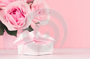 Valentine days background - elegant pastel pink roses bouquet and gift box with ribbon on white wood board, copy space, closeup.