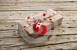 Valentine gift box and heart shape tag on wooden board