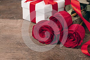 Valentine greeting card background with gift box, fresh burgundy roses and assorted hearts