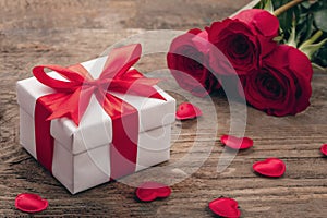 Valentine greeting card background with gift box, fresh burgundy roses and assorted hearts