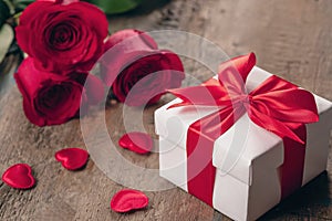 Valentine greeting card background with gift box, fresh burgundy roses and assorted hearts