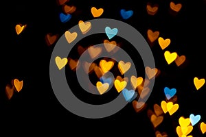 Valentine grunge heart shaped lights background. Yellow gold and blue heart-shaped on black background