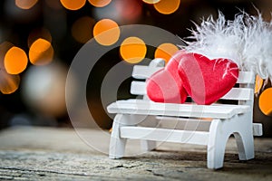 valentine heart and feather on a wooden bench