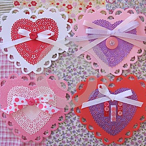 Valentine lace, doily, ribbon, and button hearts on fabric