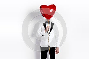 Valentine man. Handsome Boyfriend holding heart shaped air balloon. Happy Joyful man. Love. Happy Valentine`s Day