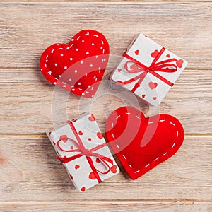 Valentine or other holiday handmade present in paper with red hearts and gifts box in holiday wrapper. Present box of gift on