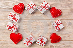 Valentine or other holiday handmade present in paper with red hearts and gifts box in holiday wrapper. Present box of gift on