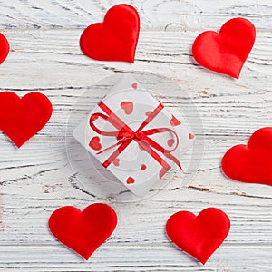 Valentine or other holiday handmade present in paper with red hearts and gifts box in holiday wrapper. Present box of gift on