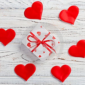 Valentine or other holiday handmade present in paper with red hearts and gifts box in holiday wrapper. Present box of gift on