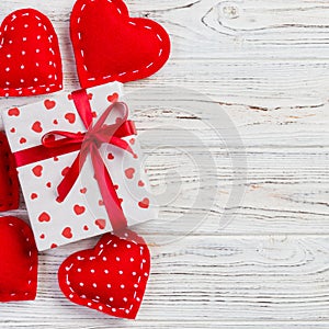 Valentine or other holiday handmade present in paper with red hearts and gifts box in holiday wrapper. Present box of gift on