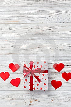 Valentine or other holiday handmade present in paper with red hearts and gifts box in holiday wrapper. Present box of gift on