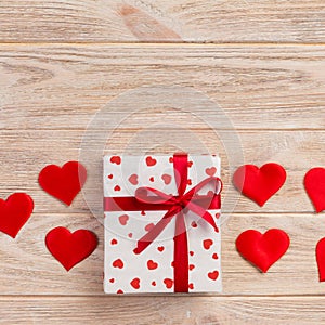 Valentine or other holiday handmade present in paper with red hearts and gifts box in holiday wrapper. Present box of gift on