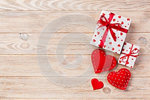 Valentine or other holiday handmade present in paper with red hearts and gifts box in holiday wrapper. Present box of gift on