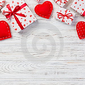 Valentine or other holiday handmade present in paper with red hearts and gifts box in holiday wrapper. Present box of gift on