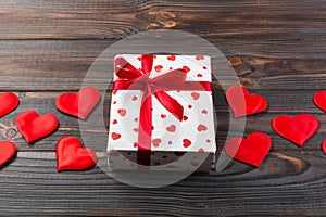 Valentine or other holiday handmade present in paper with red hearts and gifts box in holiday wrapper. Present box of gift on Dark