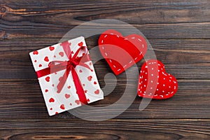 Valentine or other holiday handmade present in paper with red hearts and gifts box in holiday wrapper. Present box of gift on Dark