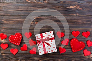Valentine or other holiday handmade present in paper with red hearts and gifts box in holiday wrapper. Present box of gift on Dark