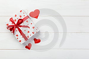 Valentine or other holiday handmade present in paper with red hearts and gifts box in holiday wrapper. Present box gift on white