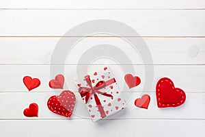 Valentine or other holiday handmade present in paper with red hearts and gifts box in holiday wrapper. Present box gift on white