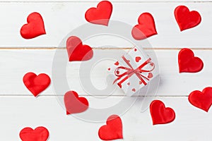 Valentine or other holiday handmade present in paper with red hearts and gifts box in holiday wrapper. Present box gift on white