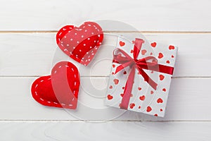 Valentine or other holiday handmade present in paper with red hearts and gifts box in holiday wrapper. Present box gift on white