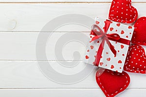 Valentine or other holiday handmade present in paper with red hearts and gifts box in holiday wrapper. Present box gift on white
