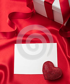 Valentine red color ruby heart on empty card on red silk fabric background