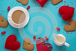 Valentine`s card and concept. Cup of black coffee with milk, red heart, sweets on blue. Top view.
