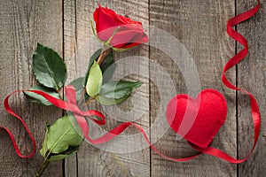 Valentine`s card. Red rose with ribbon and heart on board. Top view.