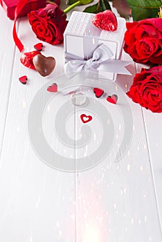Valentine`s Chocolate-Love sweet heart shaped chocolates candies with gift box on a white wooden background with red