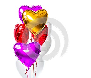 Valentine`s Day. Air balloons. Bunch of colorful heart shaped helium balloons isolated on white