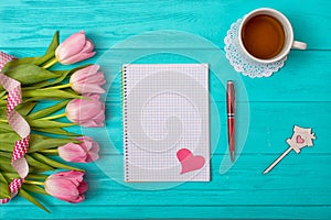 Valentine`s Day background with bouquet of tulips and an empty notebook for romantic entries.