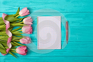 Valentine`s Day background with bouquet of tulips and an empty notebook for romantic entries.