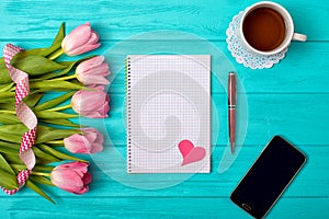 Valentine`s Day background with bouquet of tulips and an empty notebook for romantic entries.
