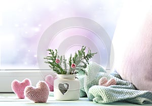 Valentine`s day background,christmas backdrop empty space.Cozy winter card.Fir tree and knitted hearts in windowsill