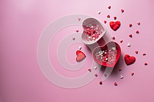 Valentine's Day background. Containers for jimmies in the shape of a heart on a pink background photo