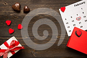 Valentine`s day background with copy space. Valentine`s Day card, gift box and chocolate on the wooden table.