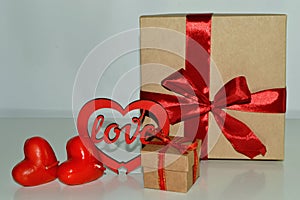 Valentine`s day background. Gift boxes with red ribbon, decorative heart and aroma candles on a white background