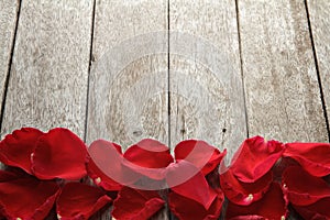 Valentine' s day background with petals of rose on wooden.