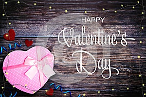 Valentine`s Day background with pink gift box, hearts and string lights