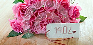 Valentine`s Day background with pink roses over wooden table.