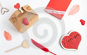 Valentine's DaRed envelope, craft box, feather and hearts on a white background. Valentine's Day concept. Flat lay photo