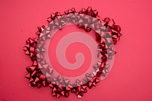 Valentine`s Day background. Red ribbon bows circle over red background, flat lay. Party, birthday, Christmas mock up