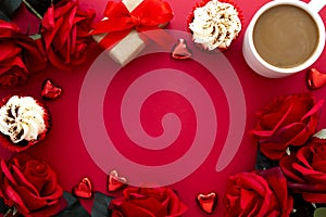 Valentine's day background, red roses, coffee cup, cupcakes, gift box and hearts on red background with copy space